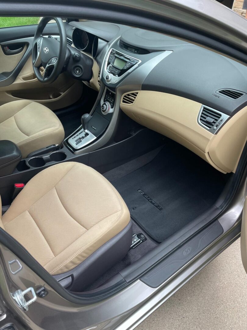 A car with tan seats and black carpet.