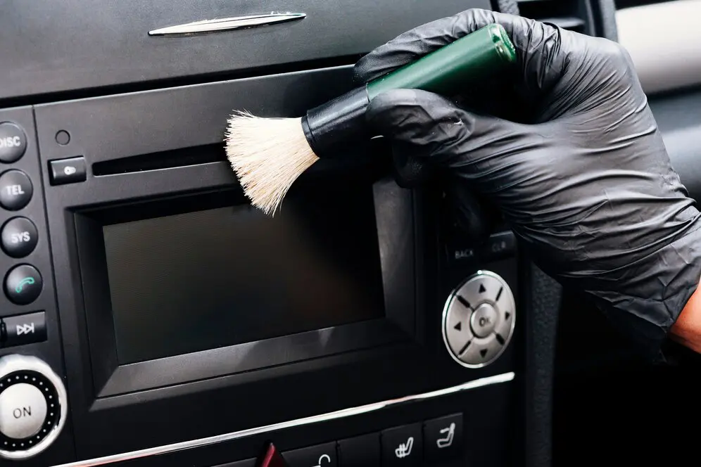 A person in black gloves is holding a hair dryer.